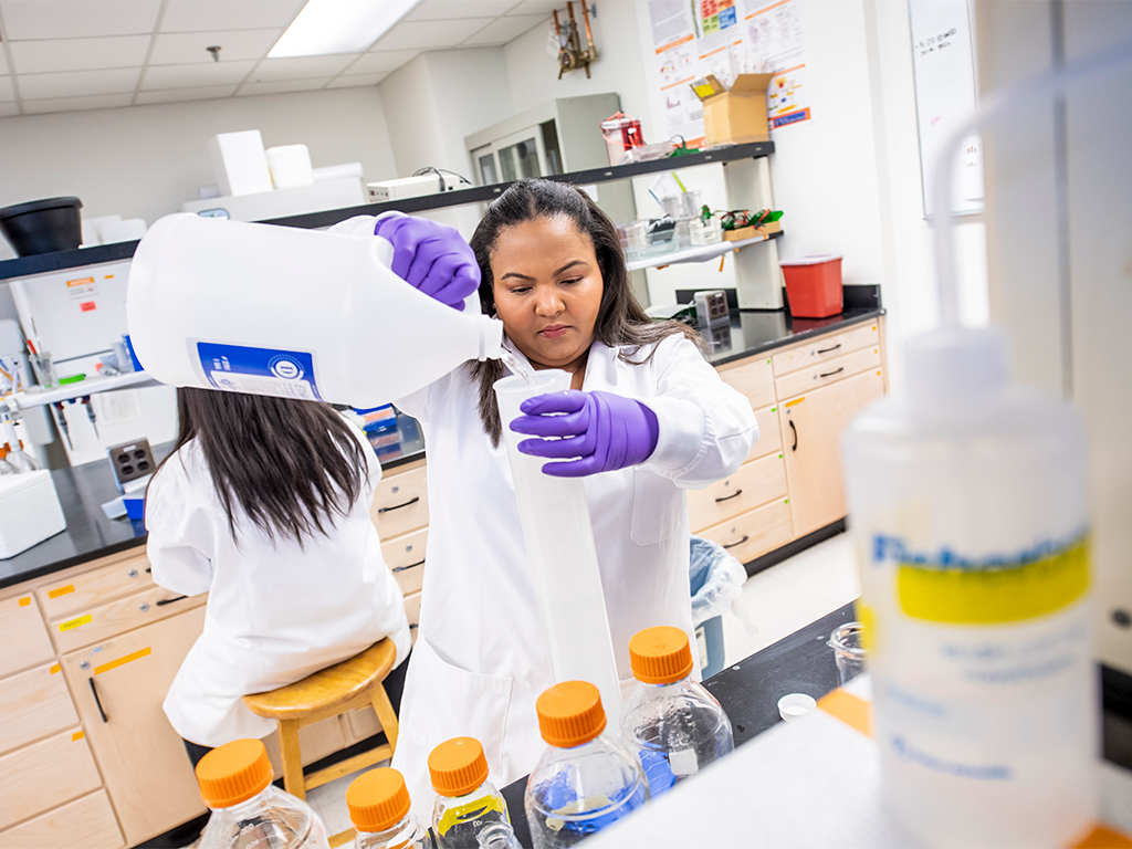 Student working with food materials in lab.