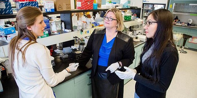 Students and professor working in lab.