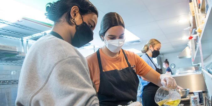 Students making food together in a kitchen