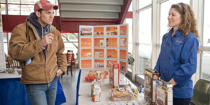 Woman showing someone different types of foods that have grains
