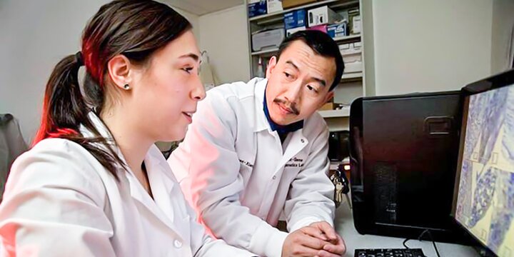 Instructor assisting a student on a computer