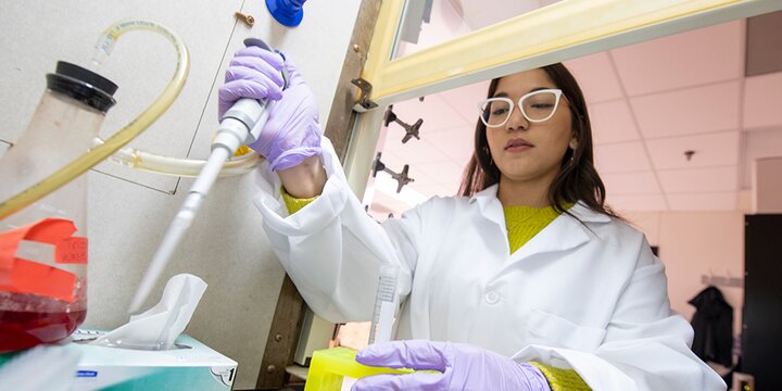 Student using analytical equipment in lab.