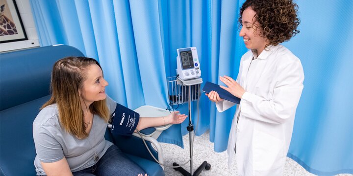 Student takes a woman's blood pressure.